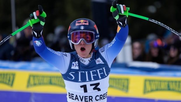 A woman skier celebrates.