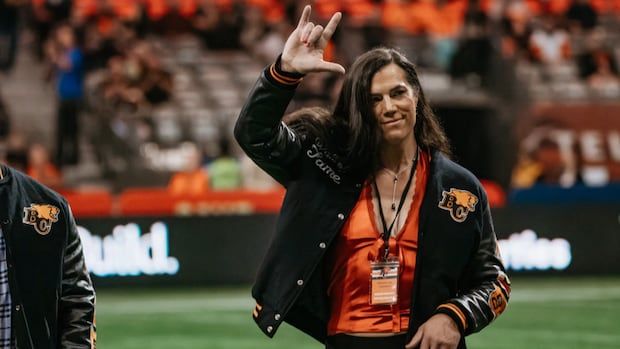 A photo of Maven Maurer in an orange top and black B.C. Lions jacket