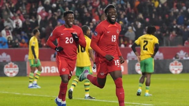 Soccer players celebrate a goal