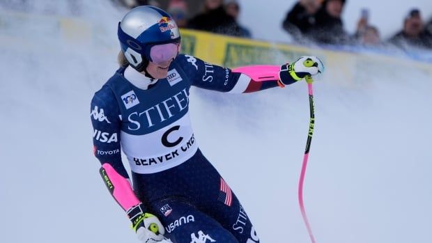 A female alpine skier smiling after finishing a run.