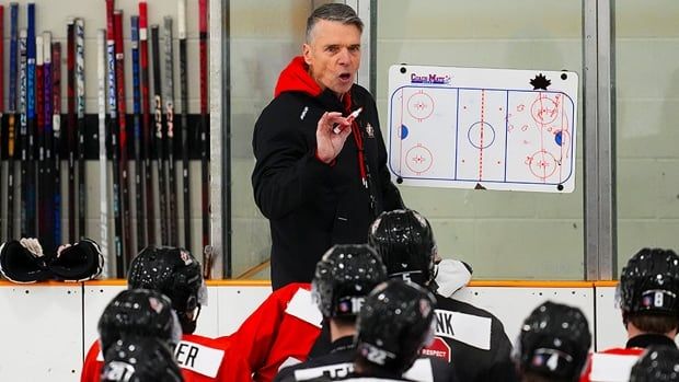 Team Canada head coach Dave Cameron talks to his players during the national junior team training camp at the Silver Dart Arena on Canadian Forces Base Petawawa in Ontario on Dec. 16, 2024.