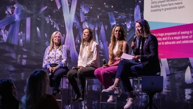 Four women sit next to each other.