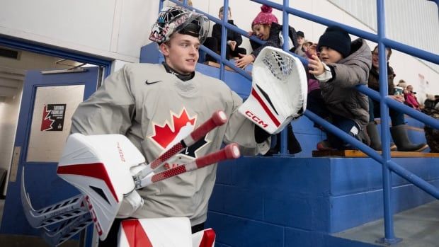 A goalie walks out onto the ice.