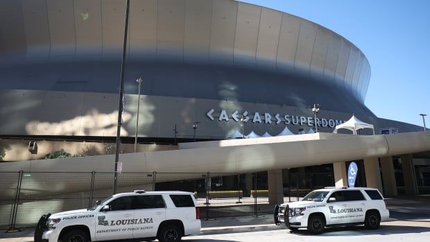 Police vehicles are seen outside a stadium.