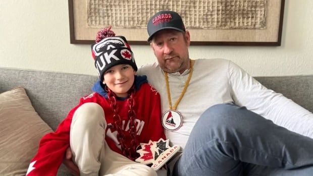 A man and his son with sad faces on a couch. 