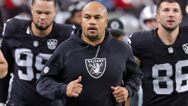 Las Vegas Raiders head coach Antonio Pierce is flanked by Andre Carter II and John Samuel Shenker leaving the field at halftime of a NFL regular-season game against the visiting Los Angeles Chargers at Allegiant Stadium on January 5, 2025 in Nevada.