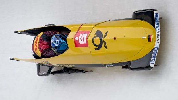 A two-man bobsleigh team are shown racing down the track.