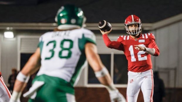 calgary quarterback is throwing the ball and a saskatchewan player is standing in the frame