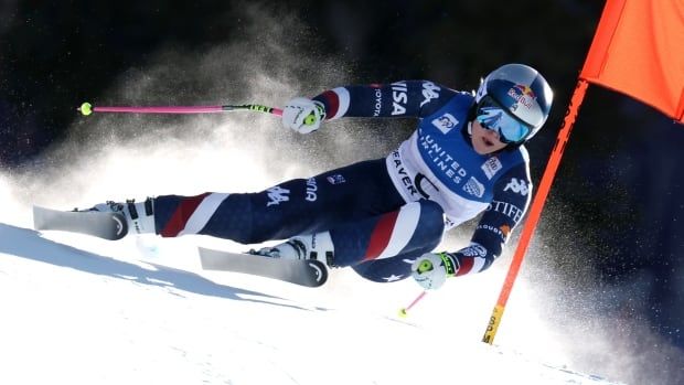 A female alpine skier races past a flag on a course.