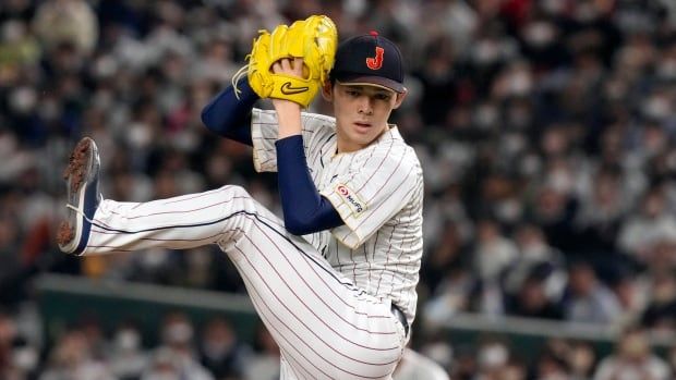 A male baseball player throws a pitch.