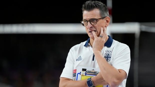 A male indoor volleyball coach reacts after his team lose a point.