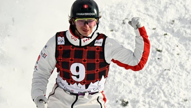 Canadian aerialist Emile Nadeau holds up his left arm with a clenched fist in reaction to his jump in the World Cup men's final on January 26, 2025 in Lac-Beauport, Quebec. 