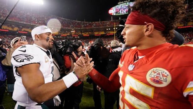 Two NFL quarterbacks shake hands after a game.