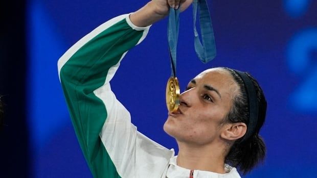 A woman kisses a gold medal