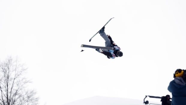 A skier does tricks in a halfpipe.