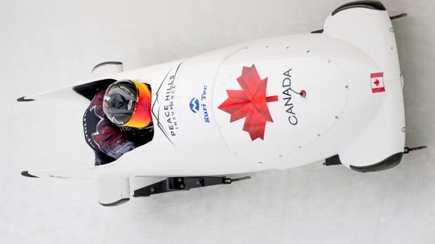 A two-woman bobsleigh team speeds down a course.