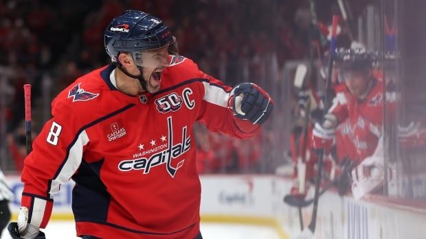 A men's hockey player celebrates after scoring.