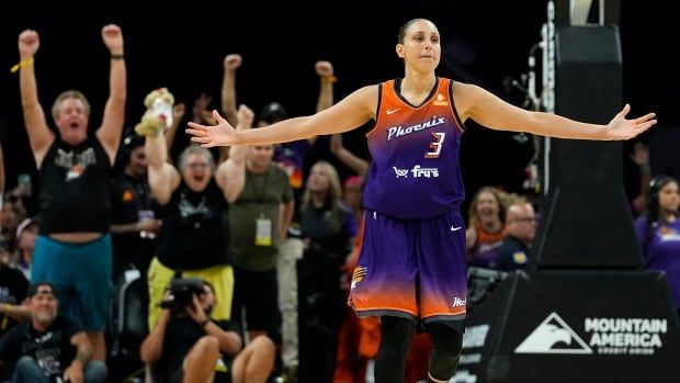 A female basketball players celebrates.