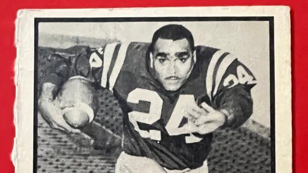 A black and white photo of a man holding a football.