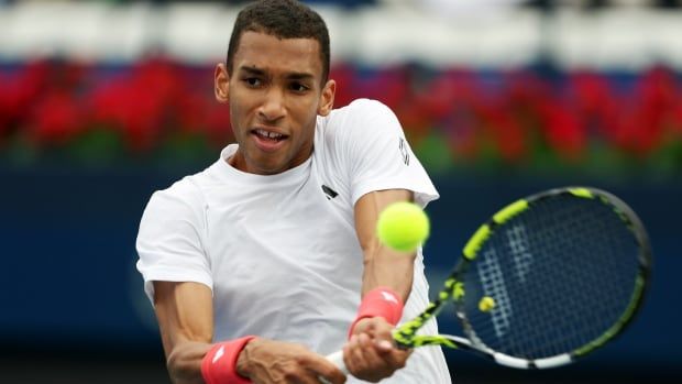 A men's tennis player takes a shot.