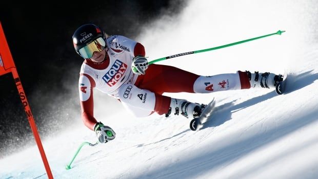 A women's skier makes a sharp turn while speeding down the course.