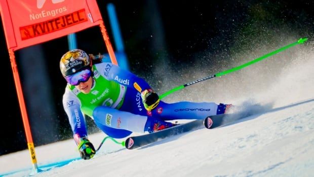 A female alpine skier races down a super G course.