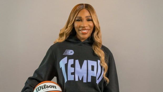 A woman poses with a basketball.