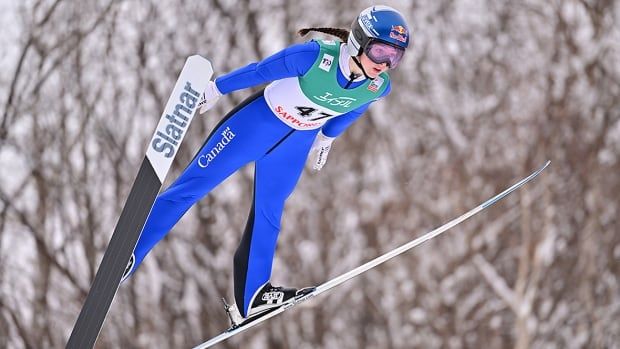 Canadian women's ski jumper pictured mid-air during women's large hill competition at World Cup event. 