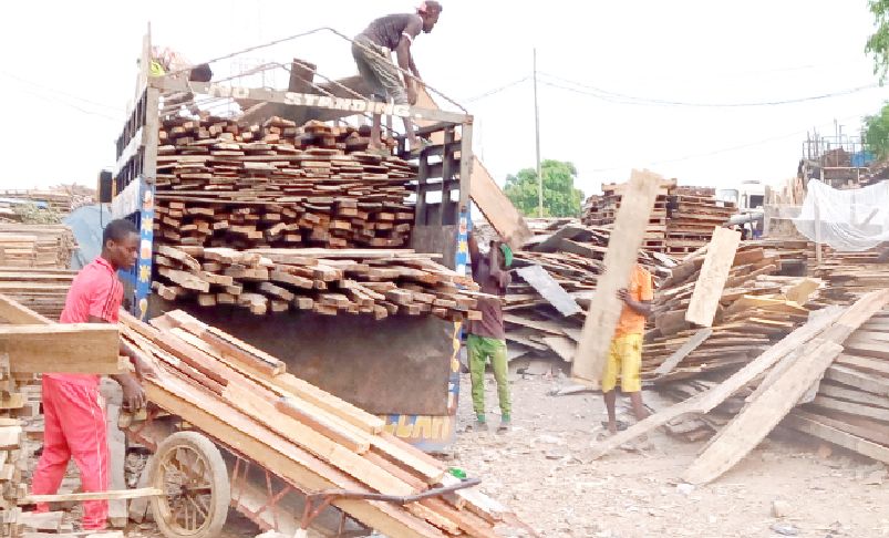 workers load woods unto a truck at daki biyu building materials market in jabi, abuja, yesterday