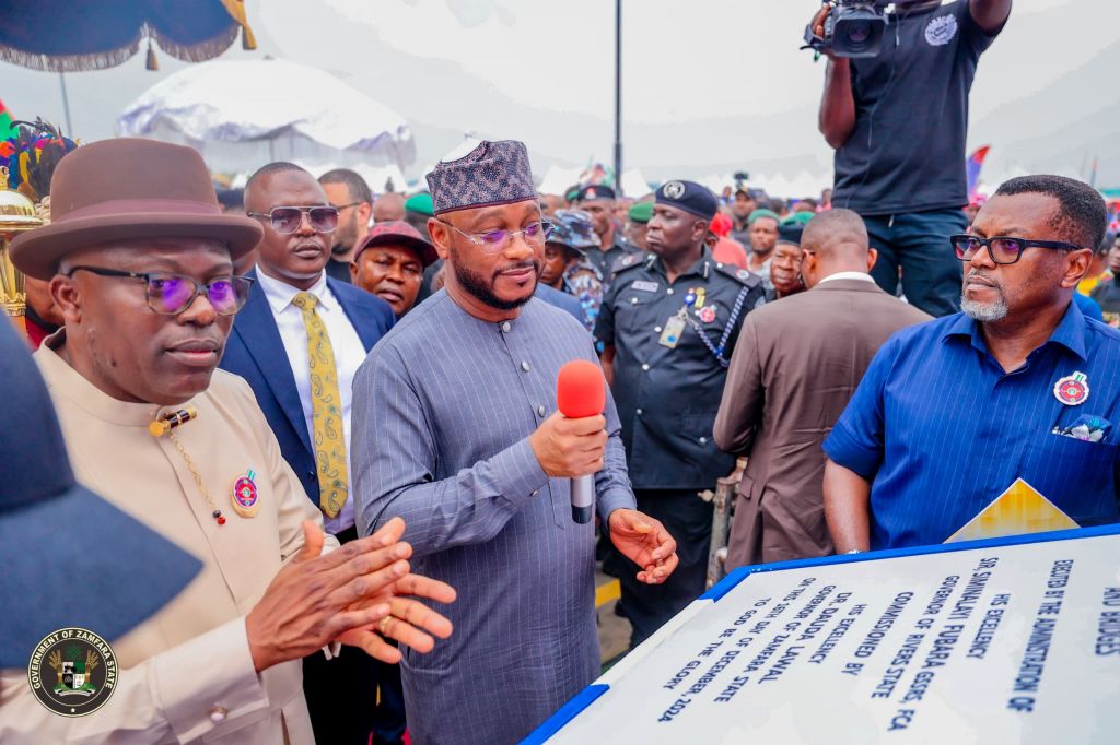 Governor Dauda Lawal of Zamfara State (centre with microphone) speaking after unveiling the plaque to commission the road while Governor Siminalayi Fubara (left) and others applaud