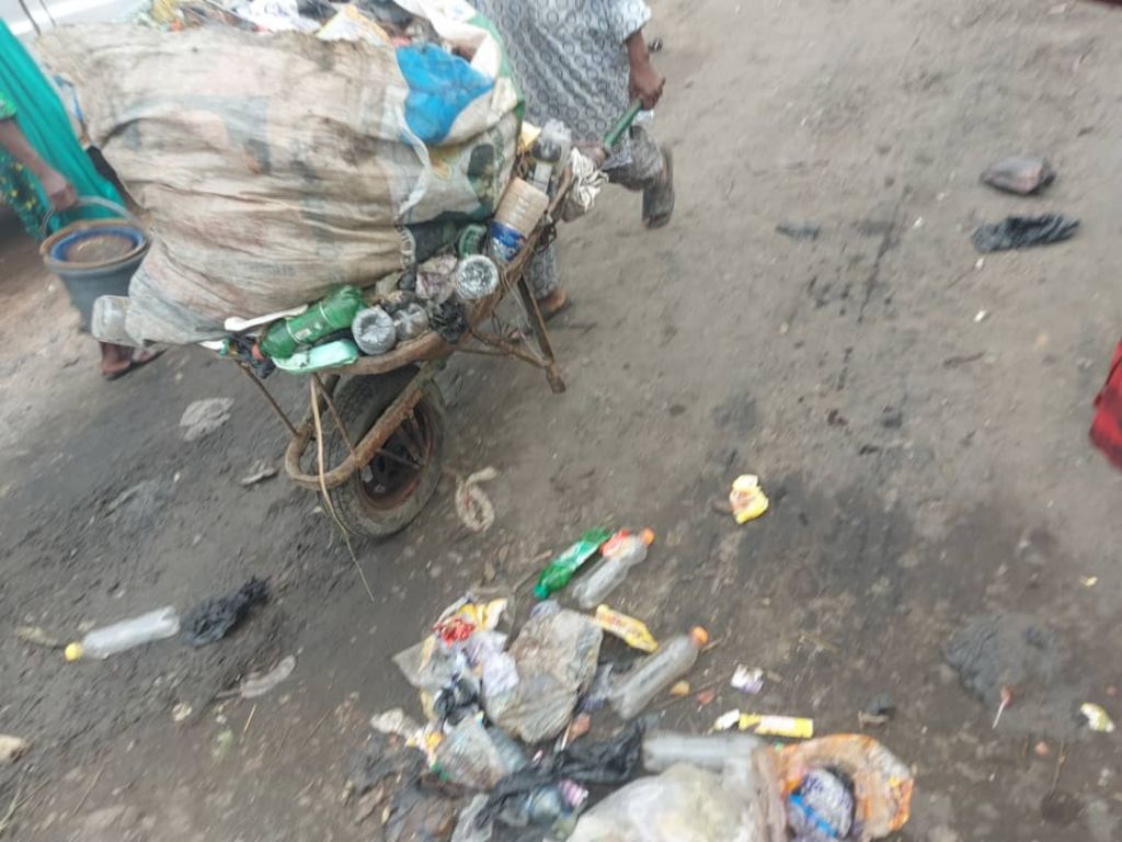 A cart pusher heading to the dumpsite to dispose of waste