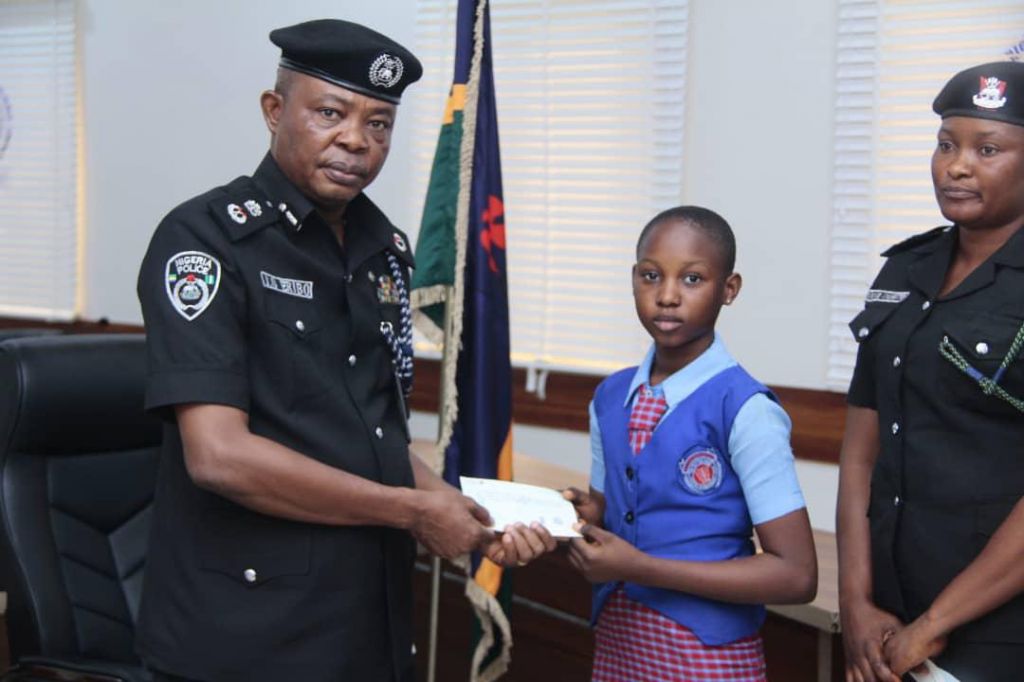 Next of kin of deceased officer receiving cheque from CP Joseph Eribo in Akwa Ibom