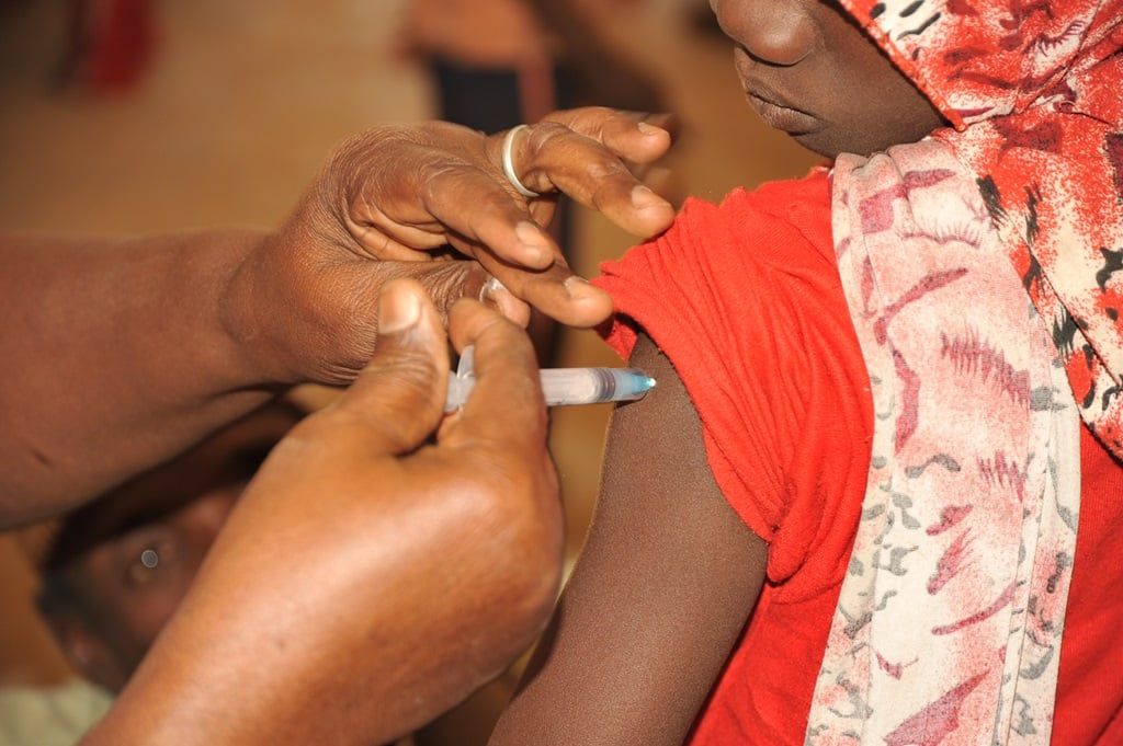 An image showing a child receiving vaccination (PHOTO CREDIT: World Health Organisation/R. Barry | via https://snip.ng/MebYq)