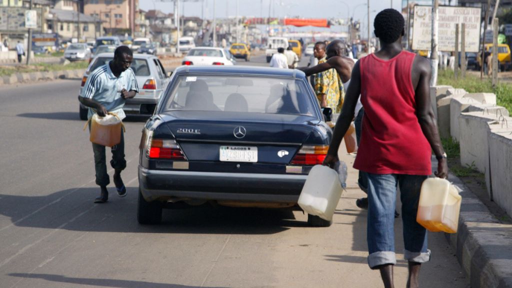 Black market fuel vendors tries to sell fuel to a motorist on Lagos-Ikorodu highway 17 June 2007. [Getty Images]