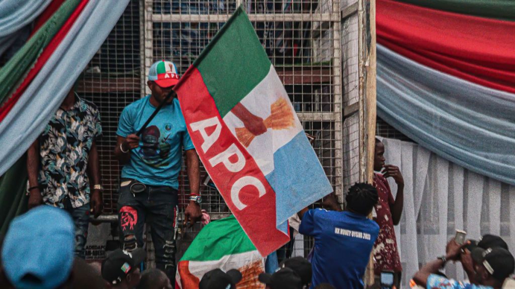 All Progressives Congress (APC) party supporters wave flags at a rally. [Getty Images]