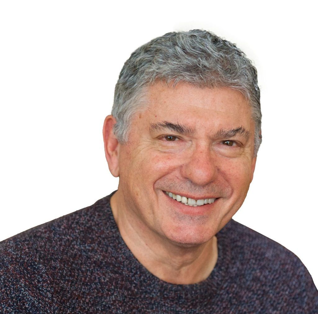 smiling headshot of man wearing jumper