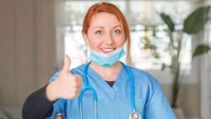 a nurse giving the thumbs up