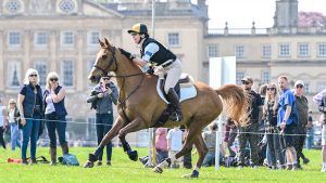 Alison Stewart and Rico III gallop in front of Badminton House at the 2024 BE grassroots eventing championships.