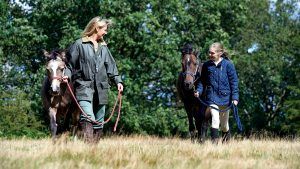 Mother and daughter leading horses together