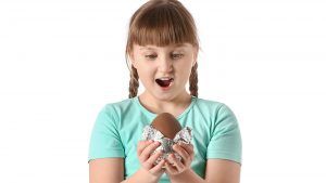 Surprised little girl with chocolate Easter egg