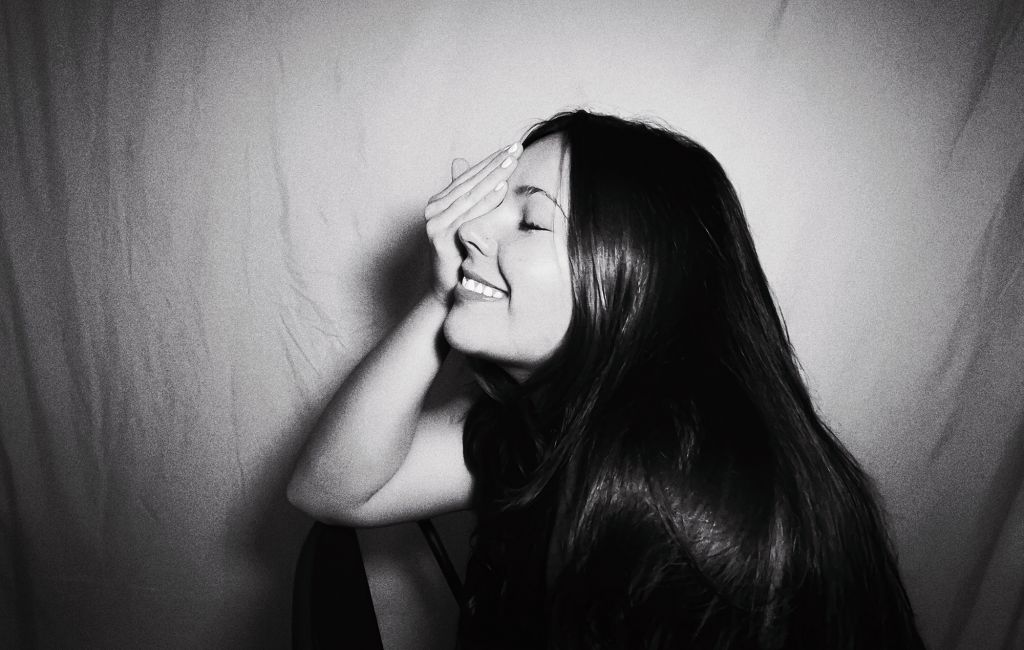 Gigi Perez photographed in black and white with her hand covering her face, photo by press