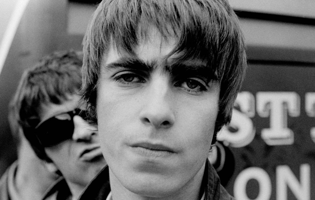 Liam Gallagher with Noel Gallagher behind (sneering, wearing sunglasses) from English rock band Oasis posed in The Netherlands in 1994. (Photo by Michel Linssen/Redferns)