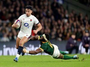 England's Marcus Smith runs with the ball as South Africa's Siya Kolisi attempts a tackle, during their teams' November 2024 encounter