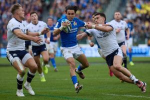 Italy’s Ange Capuozzo evades Scotland players’ tackles in the sides Six Nations 2024 match.