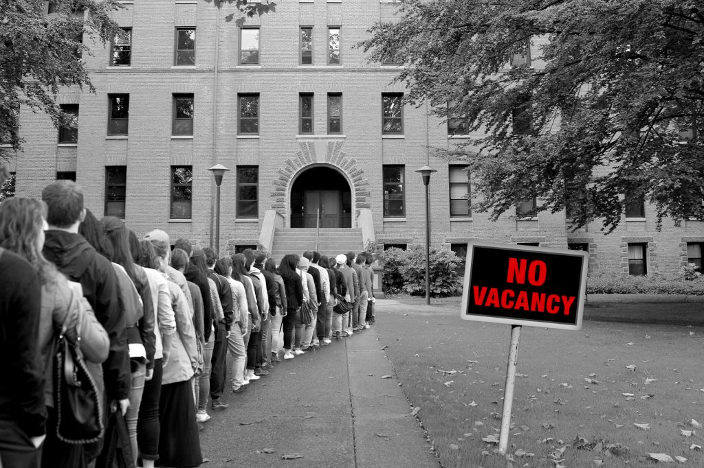 Black and white photo of students lining up waiting for housing with a red sign that says "no vacancy."