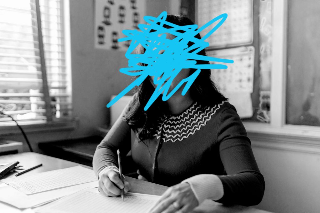 A photo illustration shows a female teacher sitting at a desk with papers in front of her and a pencil in hand, her face scratched out by a blue marker