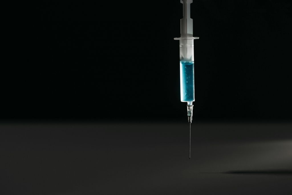 A syringe against a black backdrop.