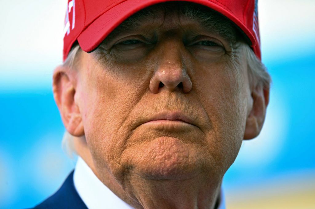 A close portrait of Donald Trump wearing a red cap