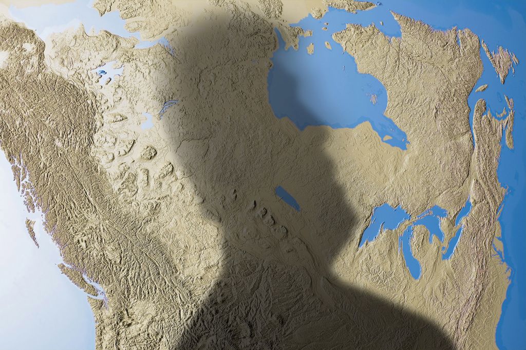 In a photo illustration, the shadow of Donald Trump falls over a map of Canada