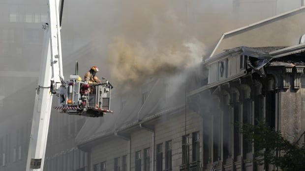 A firefighter battles a blaze in Old Montreal on Friday, Oct.4, 2024. 